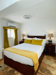um quarto com uma cama grande e almofadas amarelas em Paço Marmòris Field em Sintra