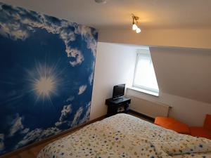 een slaapkamer met een blauwe muur met een bed en een televisie bij Lillie 3-4 Personen - Ferienwohnungen Wagner & Gaul Falkenauel in Falkenauel