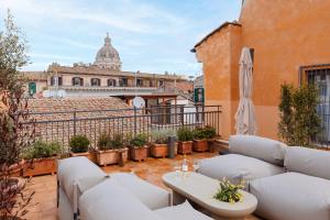 a balcony with white couches and a view of the capitolatican at Sonder Antinoo in Rome