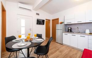 a kitchen and dining room with a table and chairs at Stunning Apartment In Razanac With Wifi in Ražanac