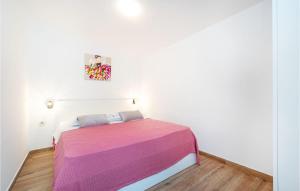 a white room with a bed with a colorful blanket at Stunning Apartment In Razanac With Wifi in Ražanac