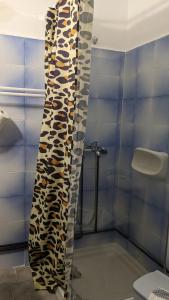 a bathroom with a shower curtain with animal print at Pension Irene in Sougia