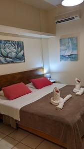 two beds in a room with red pillows on them at Pension Irene in Sougia