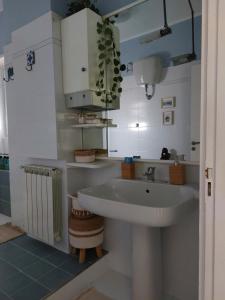 La salle de bains est pourvue d'un lavabo blanc et d'un comptoir. dans l'établissement Appartamento CasaZeta luminoso e centralissimo, à Latina