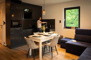 a woman standing in a kitchen with a table in a living room at Magiczne Miejsce in Szklarska Poręba