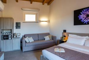 a hotel room with a bed and a couch at Chiabot Langhe in Roddino