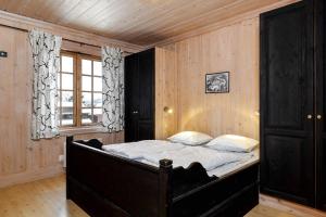 Kyrkjebøen的住宿－Tinden Apartment 310，一间带一张大床的卧室,位于带木墙的房间