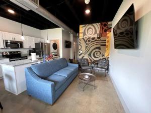 a living room with a blue couch and a kitchen at BNA Carpet Condo - 4 miles to DT in Nashville