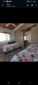 1 dormitorio con 2 camas con flores en Las Pircas alquiler temporario habitaciones y cabañas en Cafayate