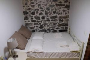 - un petit lit dans une chambre dotée d'un mur en briques dans l'établissement Natural House with Sea View & Garden, à Héraklion
