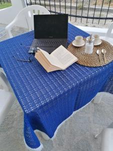 um portátil sentado numa mesa azul com um livro em Mare Verde em San Bartolomeo al Mare