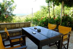 Une table et des chaises en bois sont disponibles sur la terrasse. dans l'établissement Natural House with Sea View & Garden, à Héraklion
