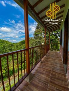 a wooden balcony with a view of the woods at HOTEL YANUBA CAMPESTRE in Pereira