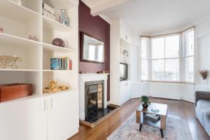 a living room with a fireplace and a couch at Beautiful Home in Camden with Garden in London