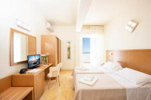 a hotel room with two beds and a desk at Hotel Mexico in Bellaria-Igea Marina +53 photos