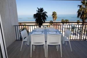 uma mesa e cadeiras numa varanda com o oceano em D Suite Fronte Mare em San Benedetto del Tronto