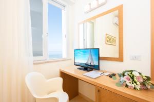 um quarto com uma secretária, um computador e um espelho. em Hotel Mexico em Bellaria-Igea Marina