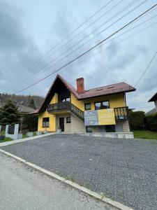 ウストロンにあるDomek pod Czantoriąの道路脇の黄色い家