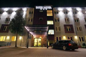 a car parked in front of a building at night at Inter Hotel in Ostrołęka