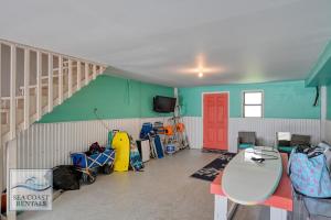 a room with a staircase and a red door at The Salted Rim in North Topsail Beach