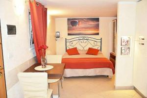 a small bedroom with a bed and a table at Olimpia House - Central Station in Bari