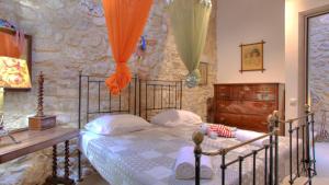 a bedroom with a bed and a stone wall at Heron's Path I in Análipsis