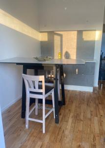 cocina con mesa con 2 sillas y barra en Lägenhet i Limhamn/sibbarp en Malmö