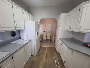 a kitchen with white cabinets and a white refrigerator at Sun Angel House #1 Pahrump in Pahrump
