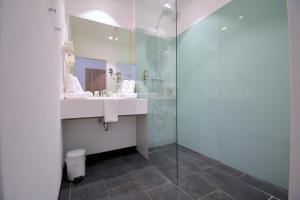 a bathroom with a sink and a glass shower at Sporthotel Zederhaus in Zederhaus