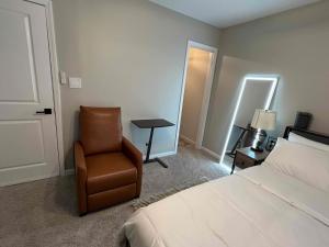 een slaapkamer met een bed, een stoel en een tafel bij HomeTel Premium Guest Suite w/ Private Entrance in Ypsilanti