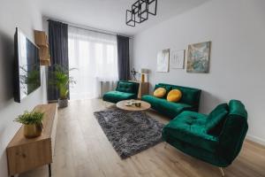 een woonkamer met een groene bank en een tafel bij Toka City Centrum in Szczecin
