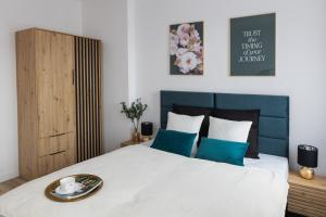 a bedroom with a large white bed with blue accents at Toka City Centrum in Szczecin