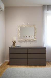uma cómoda num quarto com um espelho na parede em Regina Apartment em Pescara