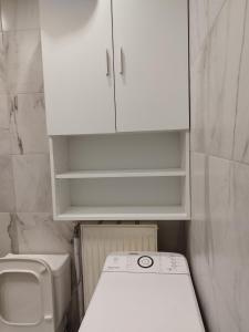 a small bathroom with a sink and a white cabinet at Cozy Studio in Athens +14 photos