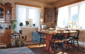 a room with a table and some chairs and windows at Pet Friendly Home In Skei I Jlster With Kitchen in Årdal