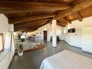 uma ampla sala de estar com tectos em madeira e uma cama em Il Girasole Apartments em Treiso
