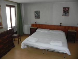 a bedroom with a large bed with white sheets at Hotel Nuovo Pecetto in Macugnaga