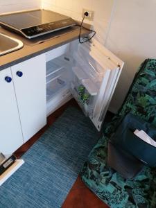 an empty refrigerator with its door open next to a desk at Mare Verde in San Bartolomeo al Mare
