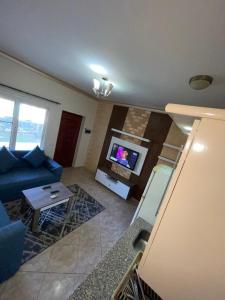 salon z niebieską kanapą i telewizorem w obiekcie Sunny lakes resort w Szarm el-Szejk