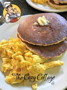 a stack of pancakes and eggs on a plate at Cozy Cottage in Miramonte