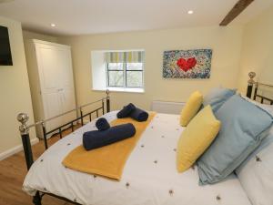 a bedroom with a large bed with yellow and blue pillows at Old Farm Cottage in Upper Sapey