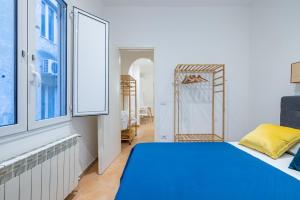 Un dormitorio con una cama azul y una ventana en Elle Cavour Apartment en Roma
