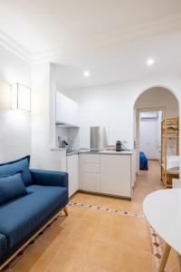 sala de estar con sofá azul y cocina en Elle Cavour Apartment en Roma