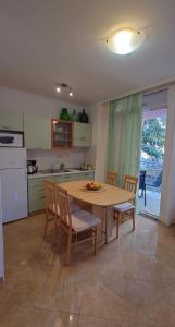 a kitchen with a wooden table and chairs and a kitchen with a refrigerator at Apartments Lola in Rovinj