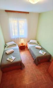2 camas individuales en una habitación con ventana en Apartments Lola en Rovinj