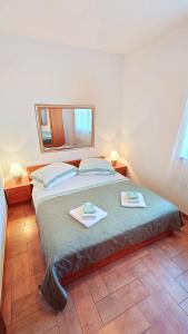 ein Schlafzimmer mit einem großen Bett mit zwei Handtüchern darauf in der Unterkunft Apartments Lola in Rovinj