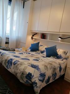 uma cama com lençóis azuis e brancos e almofadas azuis em Mare Verde em San Bartolomeo al Mare