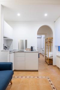 cocina con armarios blancos y sofá azul en Elle Cavour Apartment en Roma