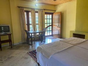 BhowāliにあるHighway Orchardのベッドルーム(ベッド1台、テレビ付きテーブル付)