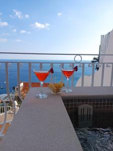 two martini glasses sitting on a table on a balcony at Hotel Il Gabbiano in Positano